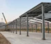 Pre-engineered steel factory building under erection on an industrial plot near Coimbatore, with steel portal frames, purlins and partly fixed roof sheets